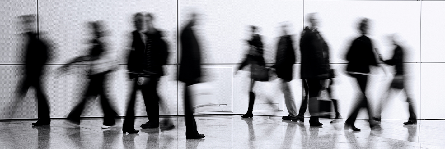 A crowd of people blurred as they walk by quickly.