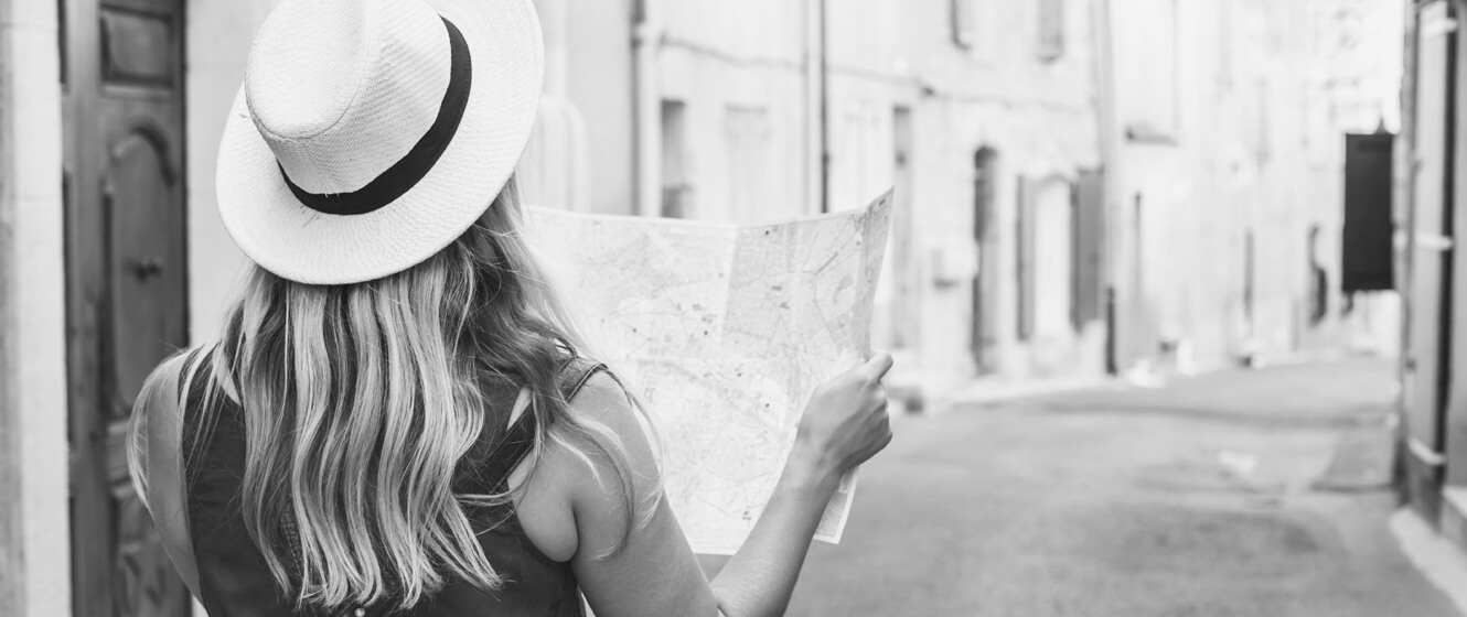 Woman wearing a sun hat and holding a map